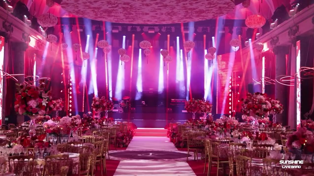 Salle de mariage fleurie, rayons de lumière sur la scène